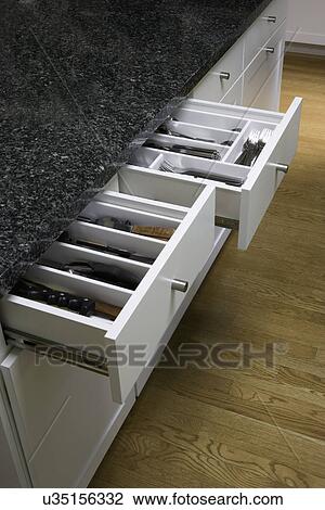 KITCHENS: close up of open utensil drawers with dividers, clean and contemporary, white cabinets with dark counters View Large Photo Image Stock Image - KITCHENS: close up of open utensil drawers with dividers, clean and contemporary, white cabinets with dark counters. Fotosearch