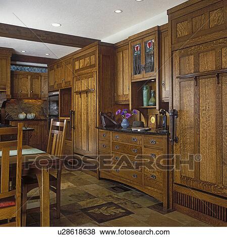 KITCHENS - Custom craftsman style white oak cabinets hide fridge, and freezer doors, buffet counter in between, vintage phone. Earth tone slate tile flooring. View Large Photo Image Stock Photo - KITCHENS - Custom craftsman style white oak cabinets hide fridge, and freezer doors, buffet counter in between, vintage phone. Earth tone slate tile flooring.. Fotosearch