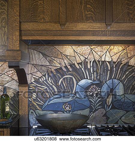 Stock Photo - KITCHENS - Detail of a slate mosaic behind stove top, depicts loons that appear on lake in spring, only top of burners visible.. Fotosearch