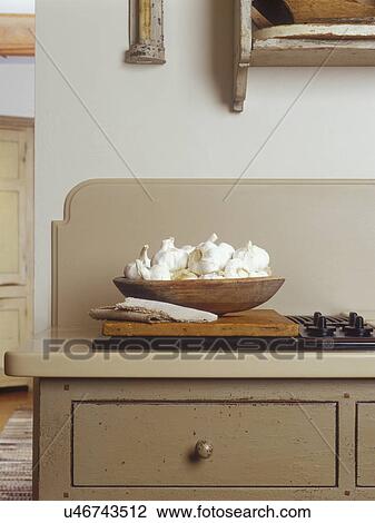 KITCHENS - Detail shot of almost hidden cooling range with backsplash. Custom designed cream colored cabinetry. Distressed finish. Bowl of garlic bulbs. Early American style ogee cut backsplash, View Large Photo Image Stock Image - KITCHENS - Detail shot of almost hidden cooling range with backsplash. Custom designed cream colored cabinetry. Distressed finish. Bowl of garlic bulbs. Early American style ogee cut backsplash,. Fotosearch