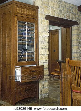 Stock Photo - KITCHENS - Stand alone wine cooler with two refrigerator drawers custom made of white oak, Craftsman styling, stone wall with entrance, slate floor.. Fotosearch