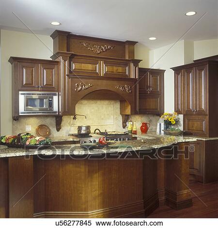 Kitchens Traditionnel Haut Gamme Sombre Bois Cabinets Et Crème Et Brun Veiné Marble Vue Vers Cuisine Secteur Orné Bois