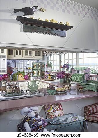 KITCHENS: View through 'pass through, ' opening shows stovetop and sink, cottage style, vintage Jade-item, wall shelf with carved crow, bunny in costume. View Large Photo Image Stock Photo - KITCHENS: View through 'pass through, ' opening shows stovetop and sink, cottage style, vintage Jade-item, wall shelf with carved crow, bunny in costume.. Fotosearch