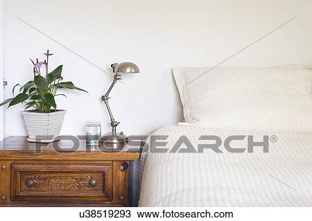 Stock Image - Lamp on side table beside bed, San Diego, California, United States of America. Fotosearch