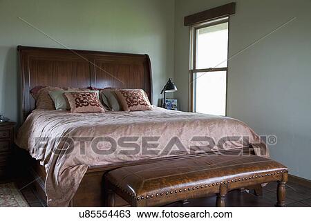 Stock Image - Leather bench at foot of master bed; Porterville; California; USA. Fotosearch