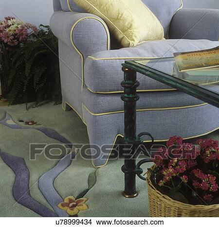 LIVING ROOM - rug and chair detail. Light blue, pale green, contrasting piping edge on upholstered chair, metal and glass table View Large Photo Image Picture - LIVING ROOM - rug and chair detail. Light blue, pale green, contrasting piping edge on upholstered chair, metal and glass table . Fotosearch