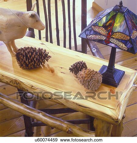 Stock Photo - LIVING ROOMS: Detail of pine console table with rough sawn log border and hand crafted stained glass lamp. . Fotosearch