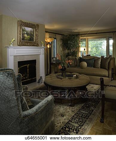 LIVING ROOMS: tufted ottoman with storage underneath, area rug, sofa, velvet chair fireplace View Large Photo Image Stock Image - LIVING ROOMS: tufted ottoman with storage underneath, area rug, sofa, velvet chair fireplace. Fotosearch