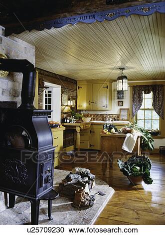 Log farmhouse kitchen with cast iron wood stove and ...