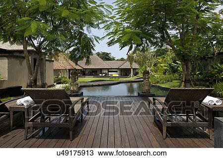 Lounge chairs in front of swimming pool View Large Photo Image Stock Image - Lounge chairs in front of swimming pool. Fotosearch