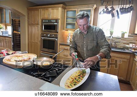 Man cooking in contemporary kitchen, Albuquerque, New Mexico, USA View Large Photo Image Stock Photo - Man cooking in contemporary kitchen, Albuquerque, New Mexico, USA. Fotosearch