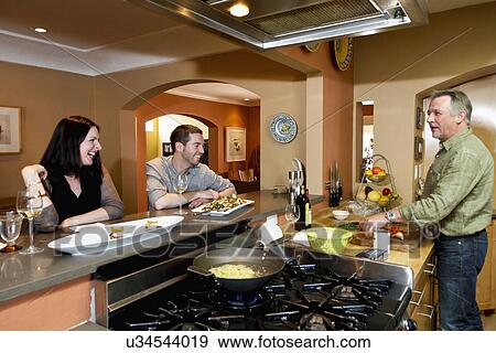 Stock Photo - Man entertaining guests at breakfast bar, Santa Fe, New Mexico, USA. Fotosearch