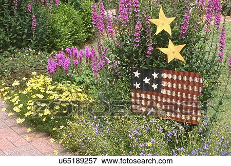 Stock Photo - Metallic flag displayed in flower garden. Fotosearch