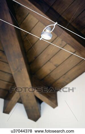 Stock Photo - Modern track light along hardwood ceiling; Italy. Fotosearch