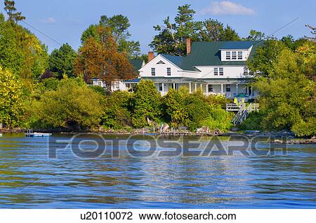 Stock Image - Multiple story home on lake, Grand Isle, Vermont, USA. Fotosearch