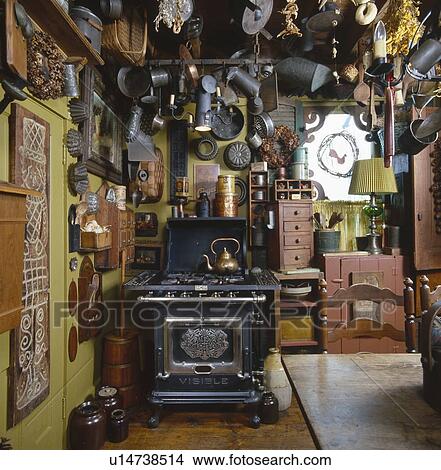 Old tin kitchen utensils and molds hanging from ceiling in country kitchen View Large Photo Image Picture - Old tin kitchen utensils and molds hanging from ceiling in country kitchen. Fotosearch