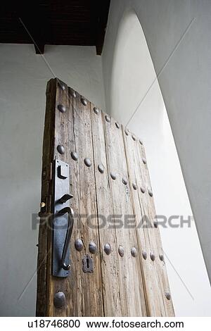 Stock Image - Old wooden door in arched doorway; Hollywood; California; USA. Fotosearch