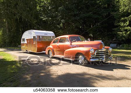 Stock Photo - Orange Pontiac pulling an orange and white trailer; Bellingham; Washington; USA. Fotosearch