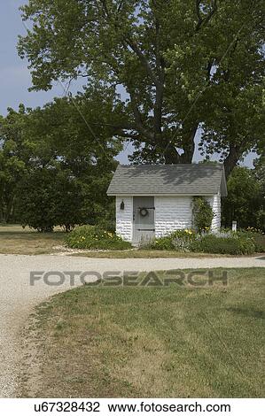 OUTBUILDINGS: farm garden shed, small white painted concrete block building with grey roof and door, wreath on door, more driveway and lawn in foreground View Large Photo Image Stock Image - OUTBUILDINGS: farm garden shed, small white painted concrete block building with grey roof and door, wreath on door, more driveway and lawn in foreground. Fotosearch