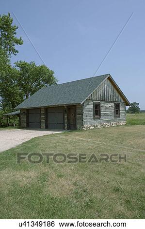 OUTBUILDINGS/ GARAGE: weathered rustic log garage, field stone foundation, two doors with a service door, two windows, lawn and driveway, vertical  View Large Photo Image Stock Photograph - OUTBUILDINGS/ GARAGE: weathered rustic log garage, field stone foundation, two doors with a service door, two windows, lawn and driveway, vertical . Fotosearch