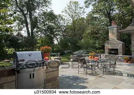 Outdoor seating furniture with stove and fireplace at patio of home. View Large Photo Image Picture - Outdoor seating furniture with stove and fireplace at patio of home.. Fotosearch