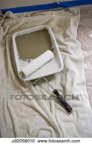 Stock Image - Paint roller in tray on towel. Fotosearch