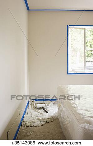 Stock Photograph - Paint roller on floor by bed, San Diego, California, United States of America. Fotosearch