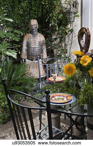 PATIO AREA: Close up of glass top table, gerberas, Asian sculpture in background View Large Photo Image Stock Photography - PATIO AREA: Close up of glass top table, gerberas, Asian sculpture in background. Fotosearch