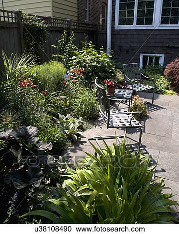 PATIO AREA: Fenced city garden and patio, stone patio flower border along privacy wood fence View Large Photo Image Stock Image - PATIO AREA: Fenced city garden and patio, stone patio flower border along privacy wood fence. Fotosearch