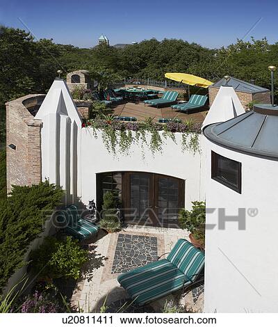 PATIO AREA: upper rooftop deck/ patio, dining area, chaise lounges, built in planter boxes, lower stone patio with striped lounge chairs and small bushes View Large Photo Image Stock Image - PATIO AREA: upper rooftop deck/ patio, dining area, chaise lounges, built in planter boxes, lower stone patio with striped lounge chairs and small bushes. Fotosearch