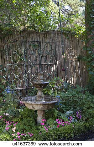PATIO AREA: wood privacy fence with iron architectural elements, fountain and shade garden in patio corner View Large Photo Image Stock Photo - PATIO AREA: wood privacy fence with iron architectural elements, fountain and shade garden in patio corner. Fotosearch