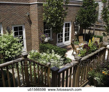 PATIO: City garden, enclosed private garden and patio, railing of deck in foreground, teak patio to right, peegee hydrangea, pin oaks surround patio, brick garage View Large Photo Image Stock Photo - PATIO: City garden, enclosed private garden and patio, railing of deck in foreground, teak patio to right, peegee hydrangea, pin oaks surround patio, brick garage. Fotosearch