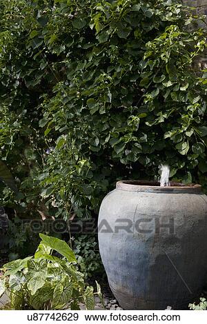 PATIO DETAIL: Pottery water fountain, city garden View Large Photo Image Stock Photo - PATIO DETAIL: Pottery water fountain, city garden. Fotosearch