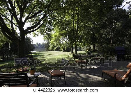 Stock Photography - PATIO; two seating areas on brick patio, barbeque to right, lake view. Fotosearch