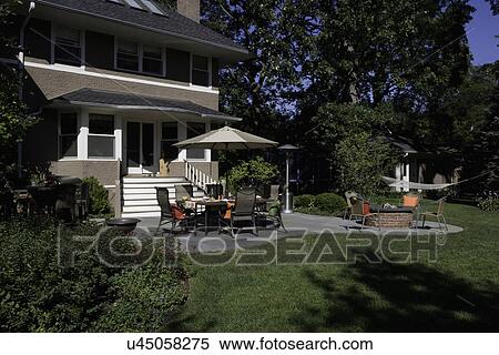 PATIO: Two story stucco, umbrella over dining area, brick fire pit, hammock View Large Photo Image Stock Photography - PATIO: Two story stucco, umbrella over dining area, brick fire pit, hammock. Fotosearch