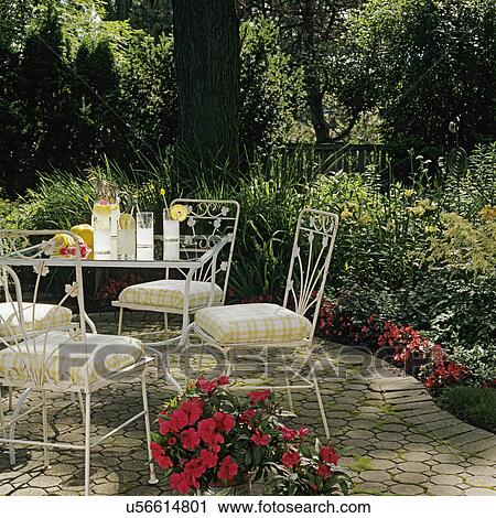 PATIOS: Close up of vintage patio set, composition brick patio, shade garden surrounds, lemonade, potted impatiens. View Large Photo Image Stock Image - PATIOS: Close up of vintage patio set, composition brick patio, shade garden surrounds, lemonade, potted impatiens.. Fotosearch