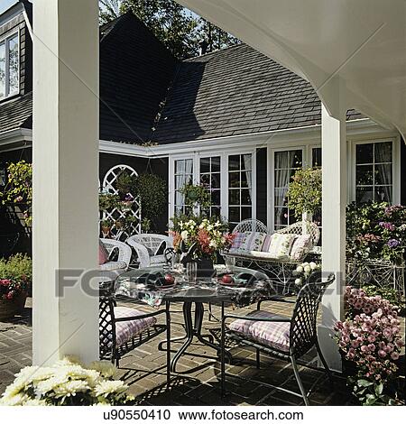 Patios Snuggled Close To The House White Wicker And Cushions