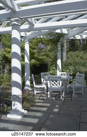 PERGOLAS: Classical white columned pergola, grey slate patio, Chinese Chippendale style patio set, no props on table closer version, View Large Photo Image Stock Photo - PERGOLAS: Classical white columned pergola, grey slate patio, Chinese Chippendale style patio set, no props on table closer version,. Fotosearch