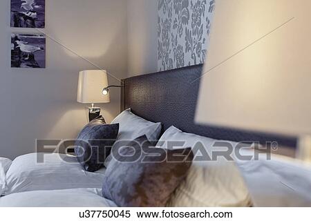 Pillows and bedside night lamp shades in bedroom View Large Photo Image Stock Photography - Pillows and bedside night lamp shades in bedroom. Fotosearch