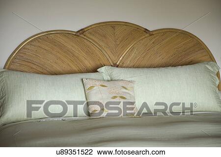 Stock Image - Pillows on bed with wooden headboard; Carpinteria; California; USA. Fotosearch