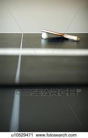 Stock Image - Ping pong paddle and ball on table, San Diego, California, United States of America. Fotosearch