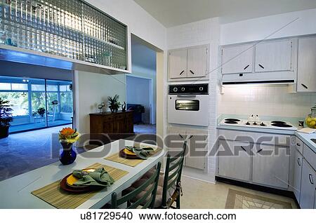 Stock Image - Place settings at breakfast bar in retro kitchen. Fotosearch