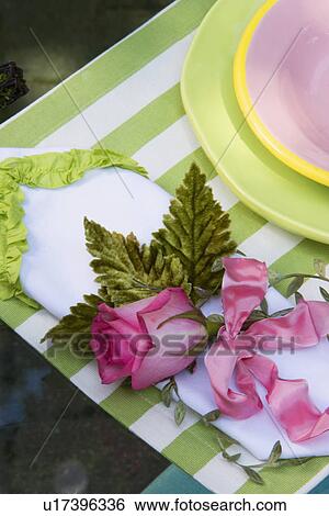 PLACE SETTINGS: cottage chic style place settings, green and white striped placemat, pink rose with ribbon as napkin holder, pottery plates in green and pink View Large Photo Image Stock Photograph - PLACE SETTINGS: cottage chic style place settings, green and white striped placemat, pink rose with ribbon as napkin holder, pottery plates in green and pink. Fotosearch