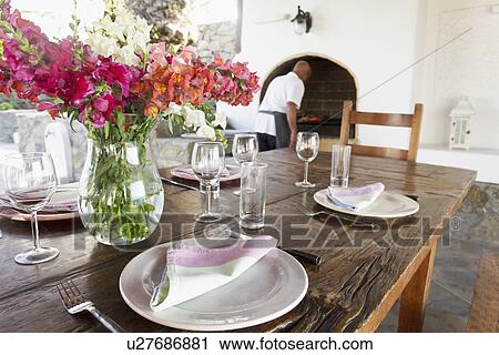Stock Image - Place settings on wooden dining table, Mykonos, Greece. Fotosearch