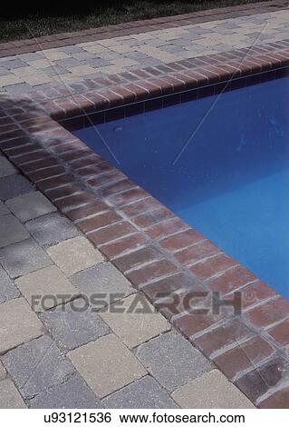 Stock Photograph - POOLS: DETAIL: Swimming pool detail, corner of patio, brick edging with stone pavers,. Fotosearch