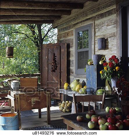 Stock Photograph - PORCH: Log home with antique, fall harvest, antique apple press, gourds. Fotosearch