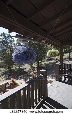 Stock Image - PORCH; Rustic porch in Colorado, hanging baskets. Fotosearch