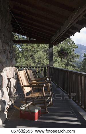 Stock Photography - PORCH; Rustic porch in Colorado, twig rockers, picnic basket. Fotosearch