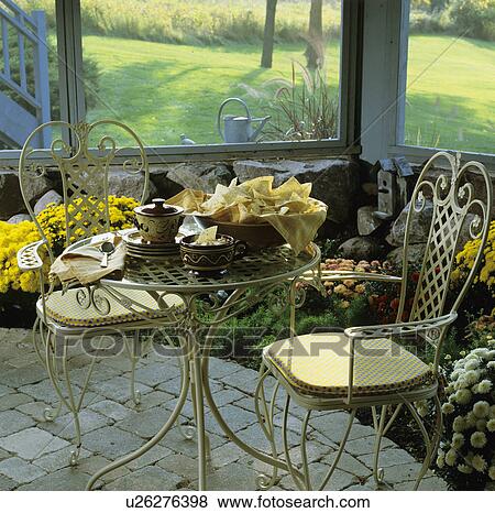 PORCH: Underneath deck, enclosed screened porch, rock foundation wall with screen above, stone pavers, flower border of mums on inside of screened porch, View Large Photo Image Stock Photo - PORCH: Underneath deck, enclosed screened porch, rock foundation wall with screen above, stone pavers, flower border of mums on inside of screened porch,. Fotosearch
