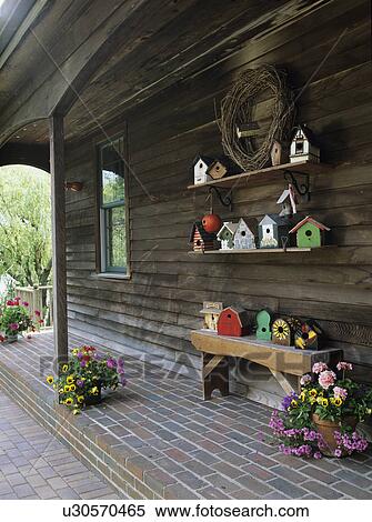 PORCHES; Rustic country porch, clapboard, brick patio, container gardens, shelving holds a birdhouse collection, antique bench also holds birdhouses View Large Photo Image Stock Photography - PORCHES; Rustic country porch, clapboard, brick patio, container gardens, shelving holds a birdhouse collection, antique bench also holds birdhouses . Fotosearch
